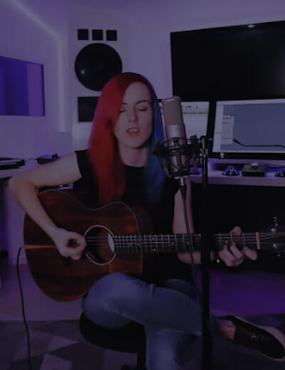Photo woman playing guitar in music studio.