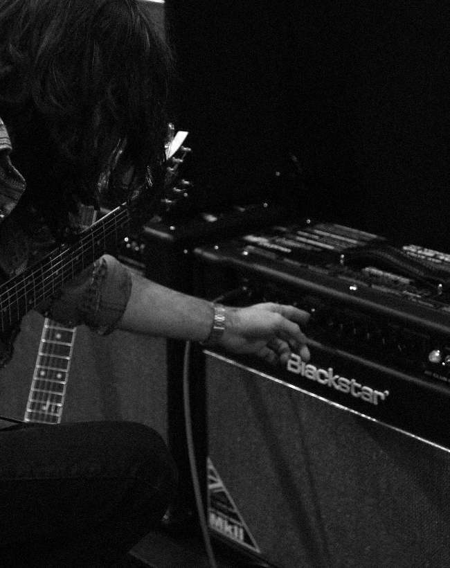 Guitarist adjusting his Blackstar amp.