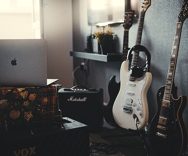 Loungeroom with electric guitars, amplifiers, and laptop