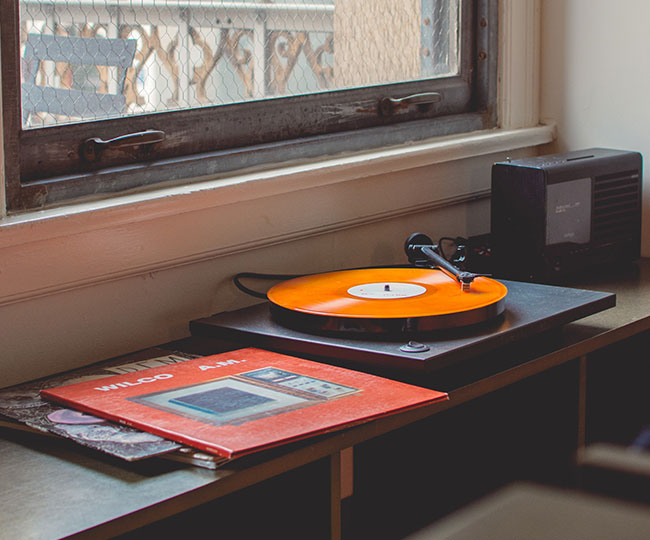 Orange Wilco record on turntable under window