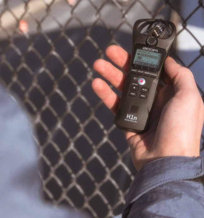 Person recording audio outside with a Zoom recorder