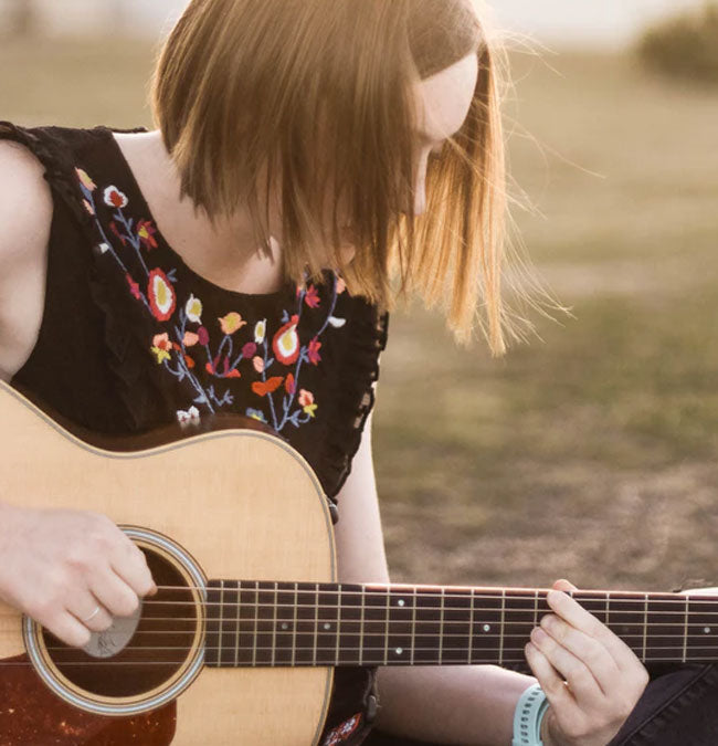 Woman playing guitar outside