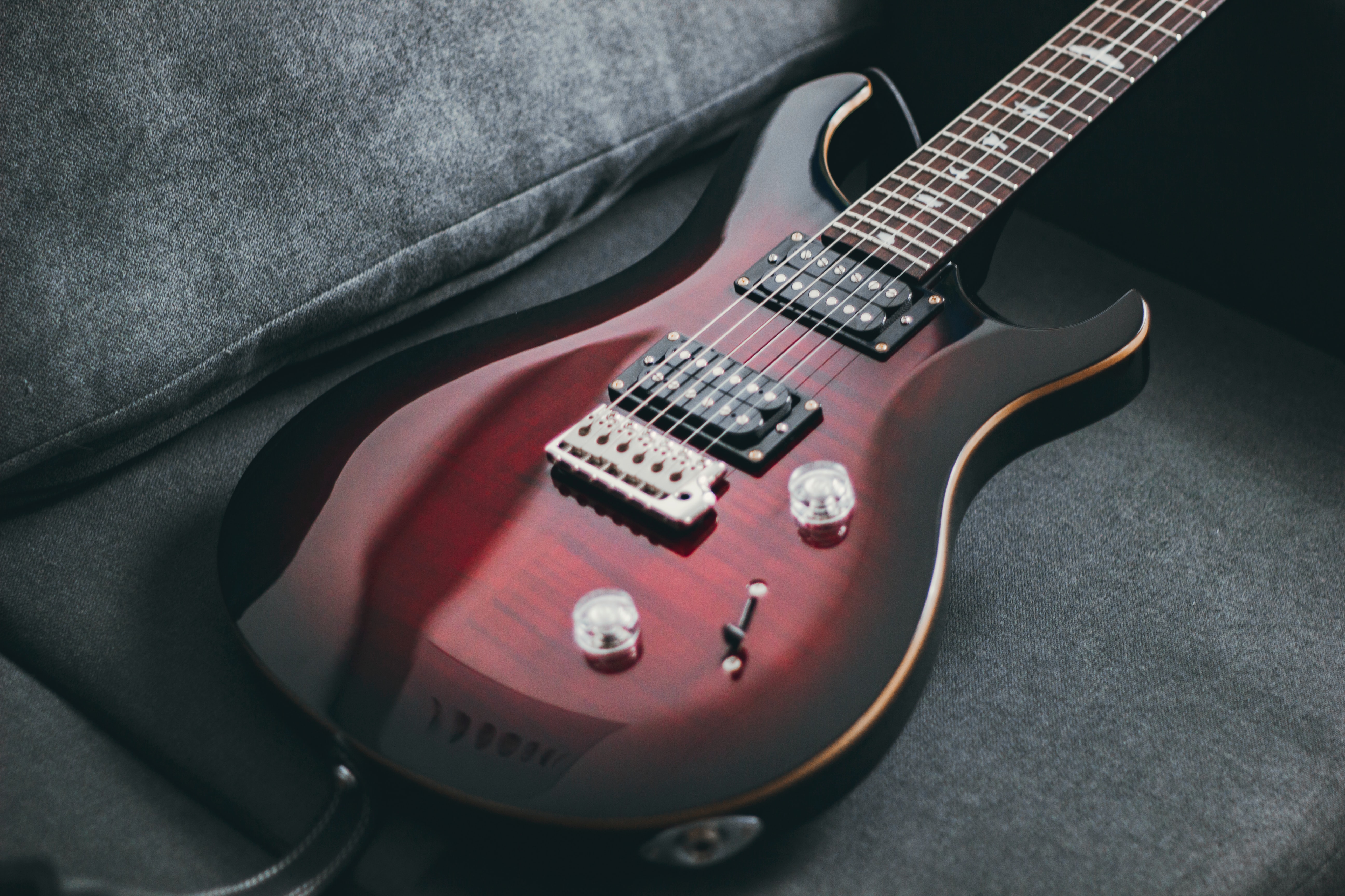 Red Burst PRS guitar on a couch