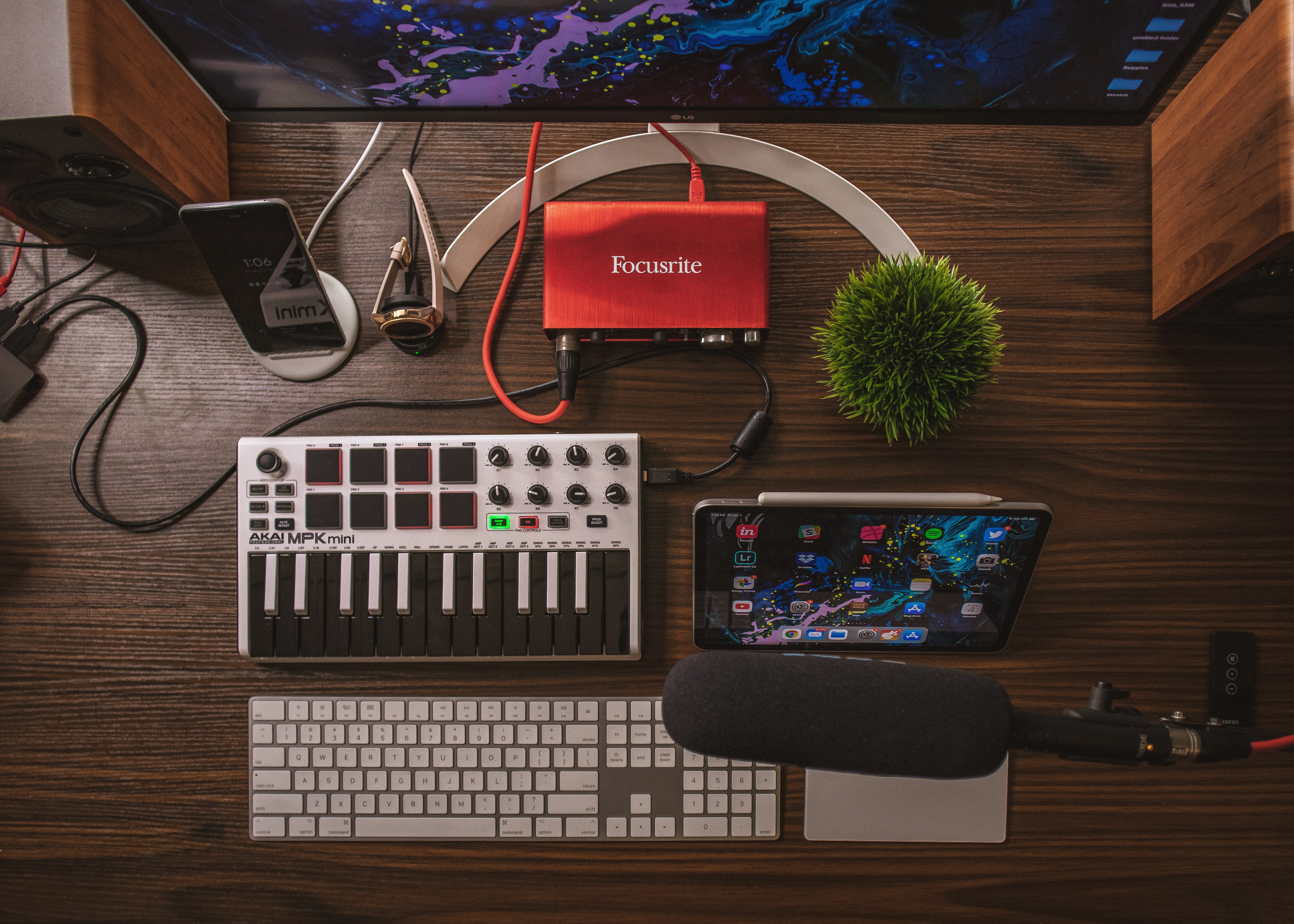 Top down view of a MIDI keyboard, audio interface and computer on a desk.