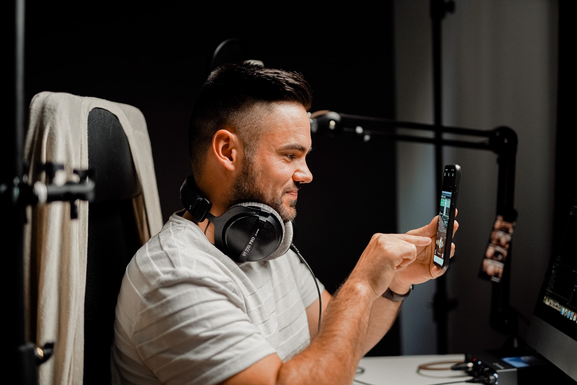 Man in studio holding up phone