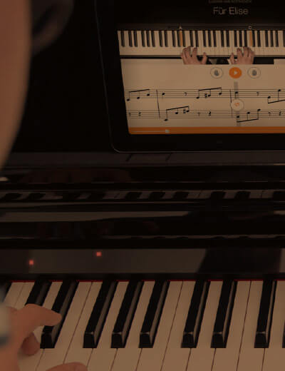 hands on piano with flowkey app on iPad