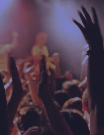 Photo of hands in the air at a concert.