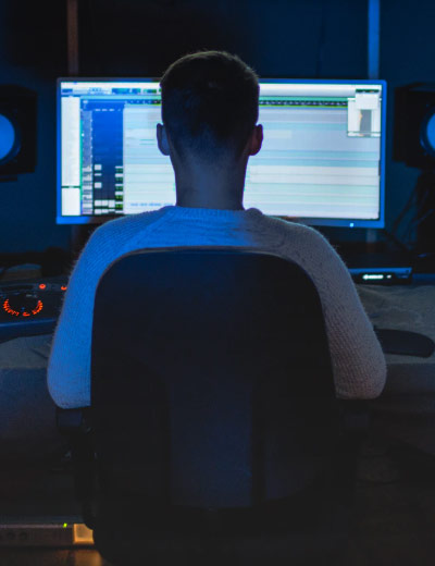 Man sitting in front of computer making music